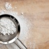 Powdered sugar being sifted using a screen.