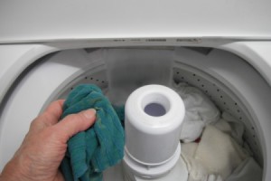 Using a wet washcloth to wipe down the washer and dryer.