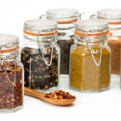 Several glass spice jar full of bulk spices.