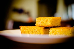 Three pieces of cornbread on a plate.