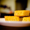 Three pieces of cornbread on a plate.