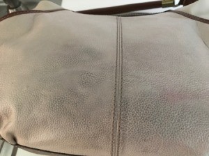 A leather bag that has some discolored marks.