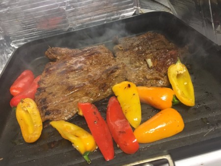 meat and peppers cooking in skillet