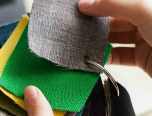 A woman holding several fabric samples.