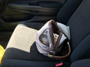A purse being stored in a passenger seat.