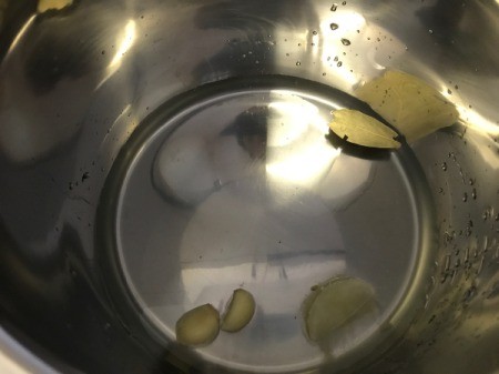 adding lemon juice, garlic and water to pan