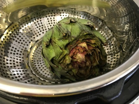 adding artichoke to pan