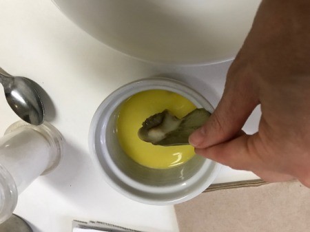 dipping artichoke leaf in butter