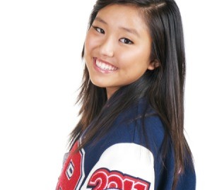 A teen female high school athlete wearing a letterman jacket.