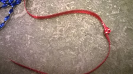 A piece of ribbon with a knot a few inches from the end of a piece of ribbon