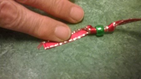 A bead added to the end of the ribbon, attached with a knot on either side.