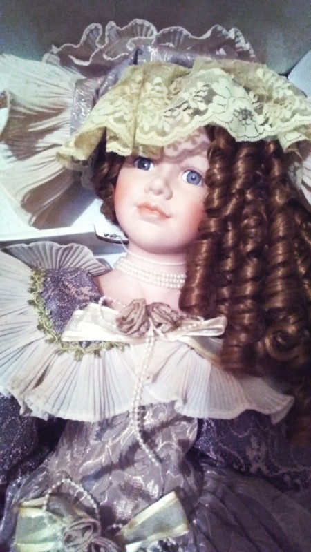 Porcelain doll with brunette hair.