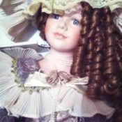 Porcelain doll with brunette hair.