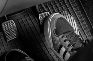 Photo of someone's foot on a car's gas pedal.