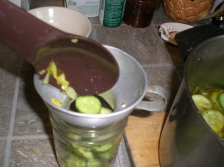 filling jar with cut cucumbers