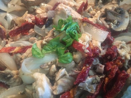 adding basil and sun dried tomatoes