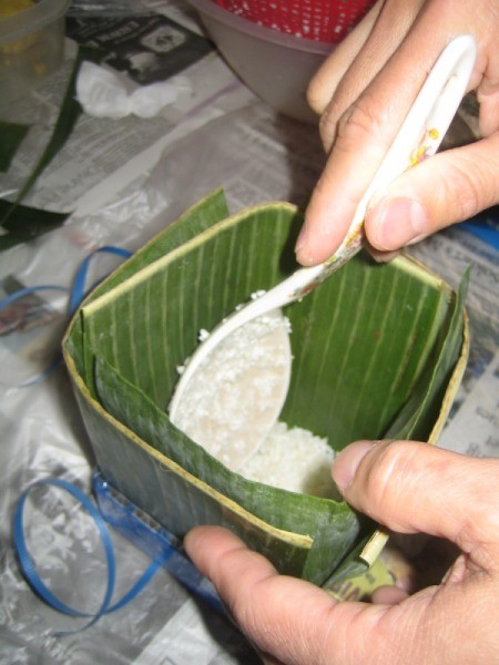 adding rice to banana leaf square