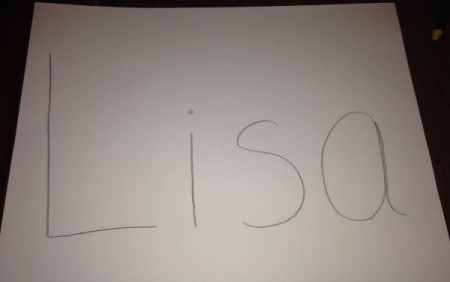 A piece of paper with the name "Lisa" printed in pencil.