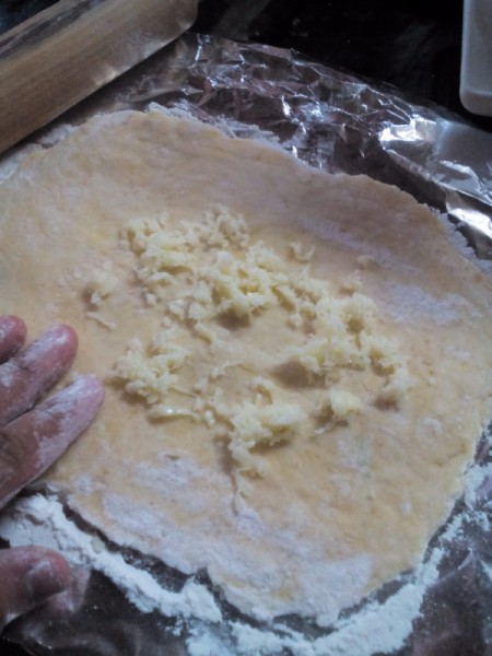 adding grated cheese to dough