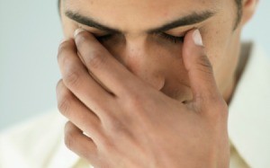 A man touching his eye lid.