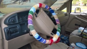 The attached multicolored crocheted steering wheel cover.