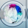 White clothes along with blue colored clothes inside a washing machine.