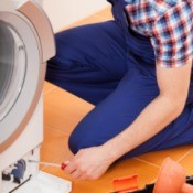 A man repairing a washing machine.