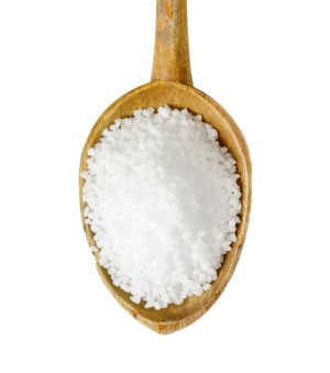 A wooden spoon full of epsom salts.