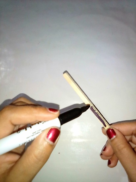 Coloring a stick black with a marking pen, for the ninja sword.