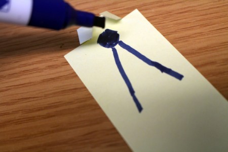 Drawing a tie below the collar fold on the white paper.