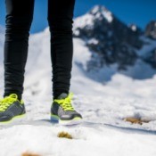 A woman wearing running shoes in the snow.