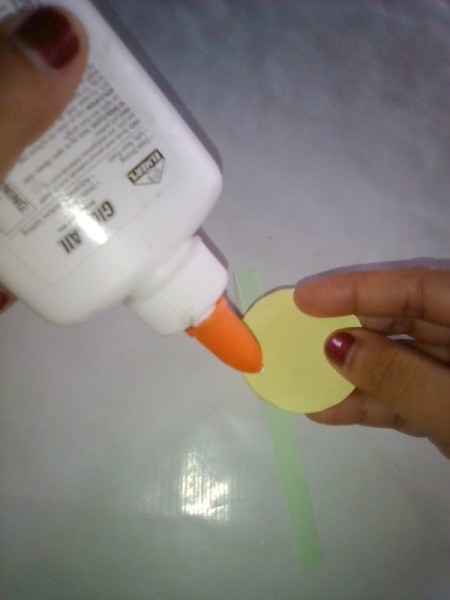 Simple Flowers with Paper Vase - applying glue to the back of a yellow paper circle