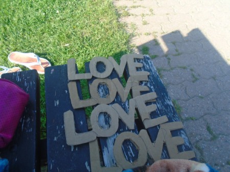 'Love' Cardboard Sign - four pieces of paper with the word "love" spelled out