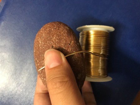 Wire Spiral Picture Holder - beginning to wrap copper wire around a rock