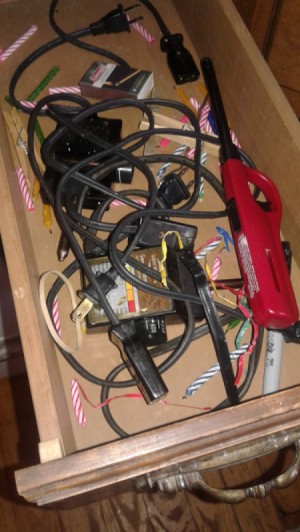 A drawer of cords that are disorganized.