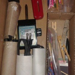 A drawer with the cords neatly stored inside cardboard tubes.