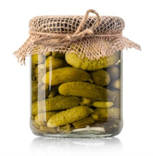 A jar full of pickles and pickle juice.