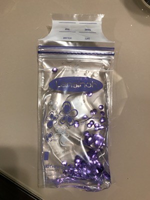 A storage bag for breastmilk with sequins and water, as a toddler toy.
