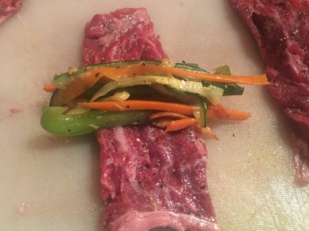 seasoned flank steaks with veggies on top