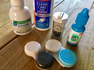 A collection of different products for caring for contact lenses.