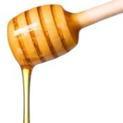 Honey dripping off of a honey dipper.