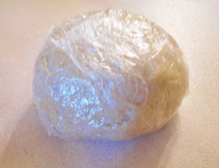 plastic wrapped ball of dough