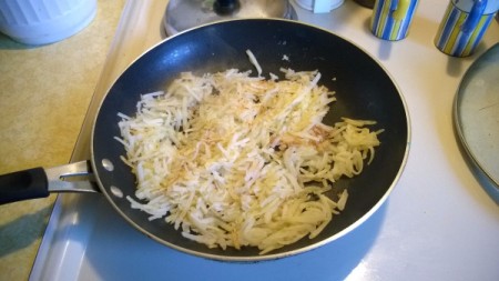 hash browns cooking in pan