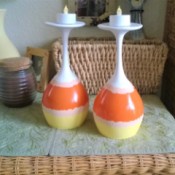 Wine glasses painted to resemble candy corn, placed upside down with battery operated candles inside.
