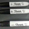 Large black Sharpie brand markers, with a plus or minus drawn on them.