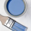 A can of blue paint and a paint brush.