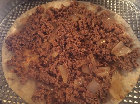 adding ground beef mixture to tortilla