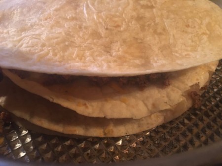 making another layer of tortilla, ground beef and cheese