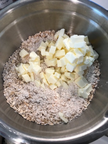 butter cubes in bowl with dry ingredients