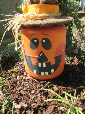 A helium tank that has been painted and decorated as a Jack-'o-lantern.